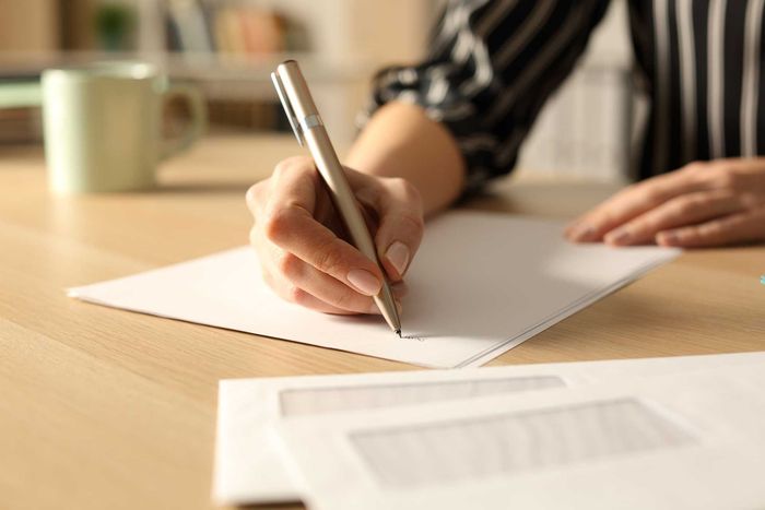 Woman hands writing letter in the night at home
