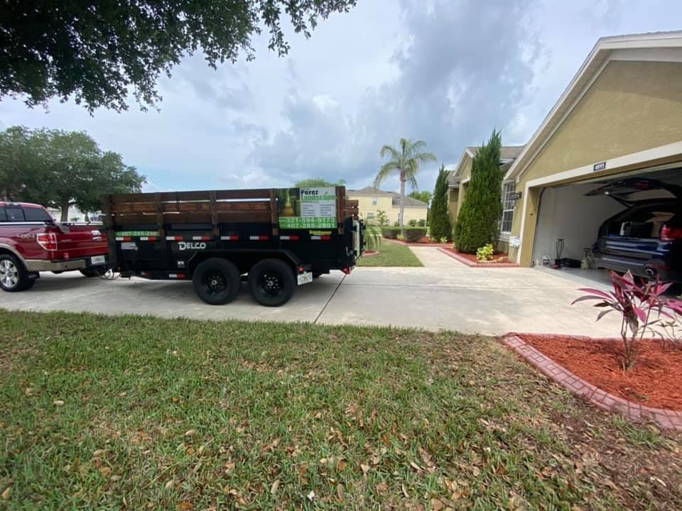 A dump truck is parked in a driveway next to a house.