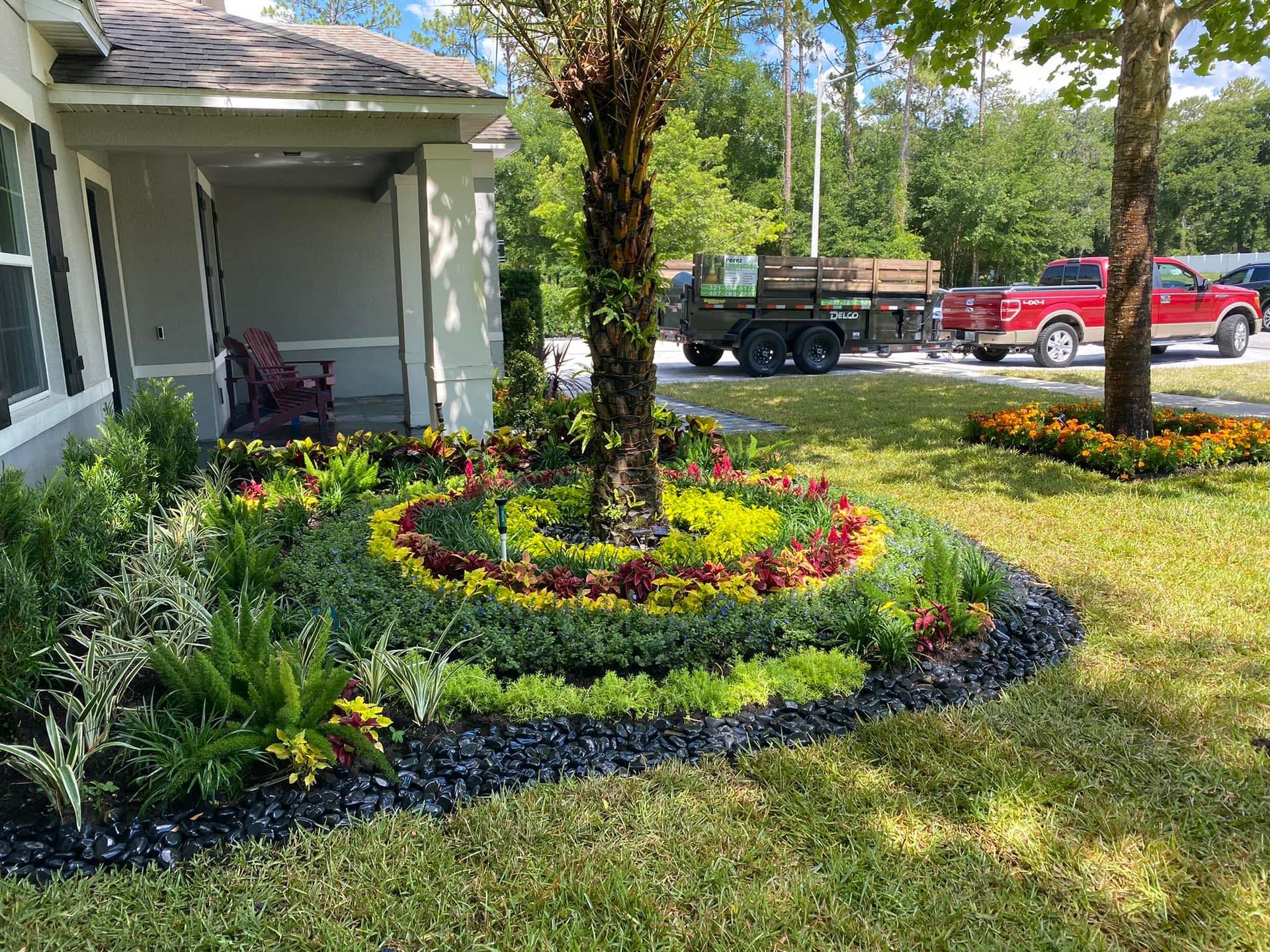 A house with a lush green lawn and a truck parked in front of it.