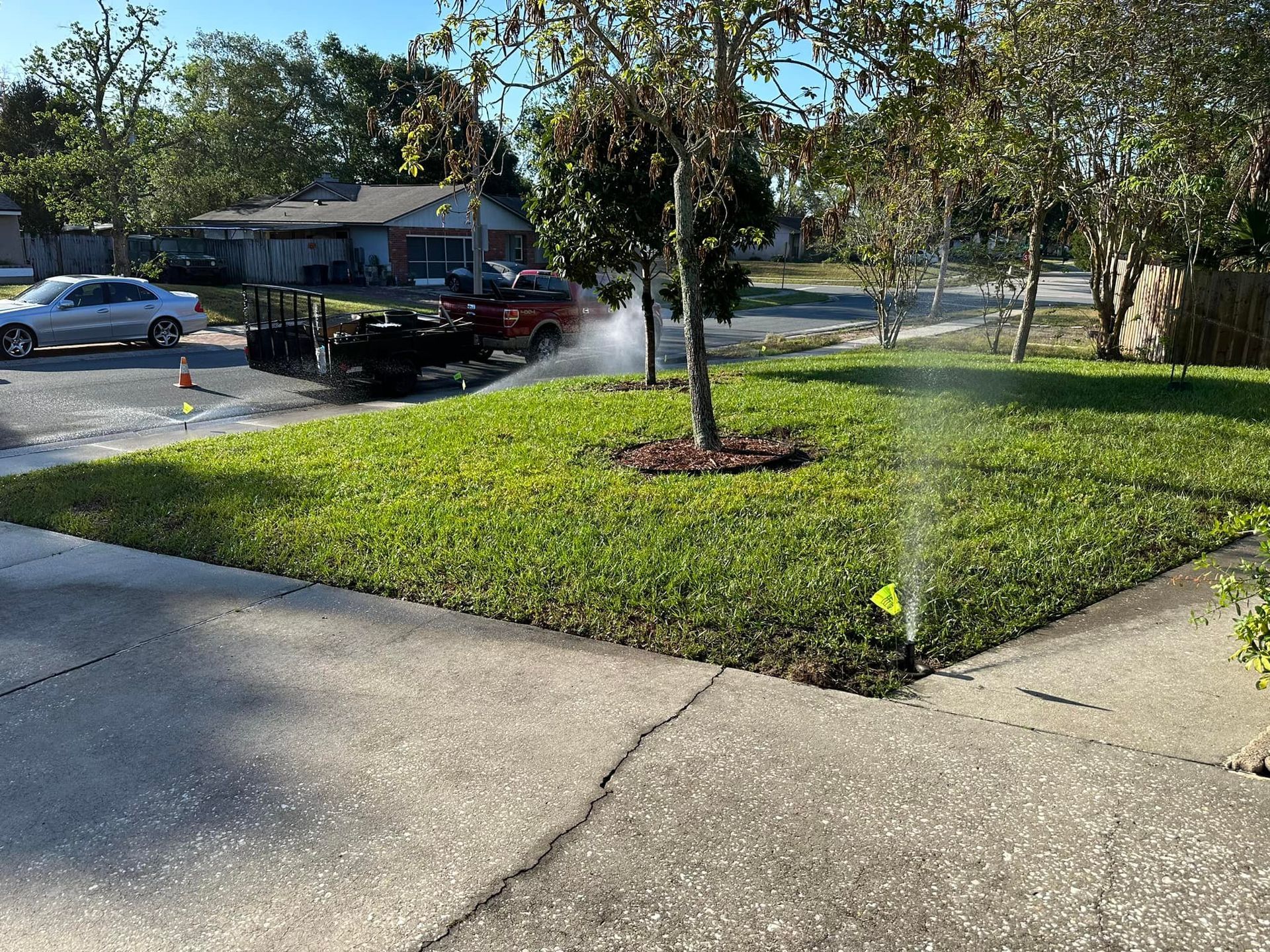 A lawn sprinkler is spraying water on a lush green lawn.