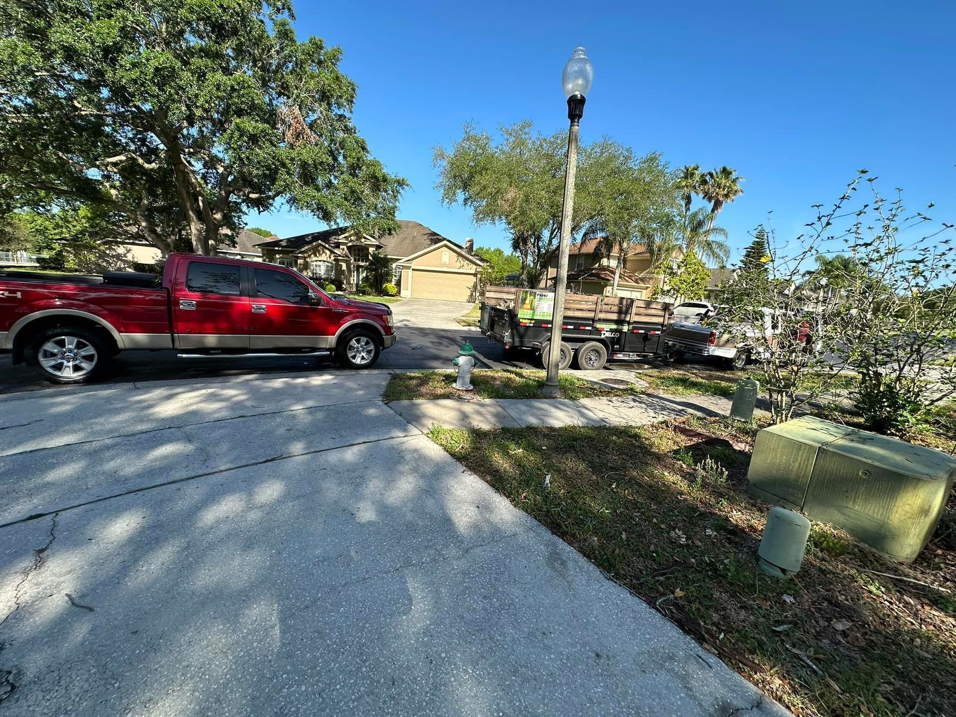 A red truck is parked in the driveway of a house.
