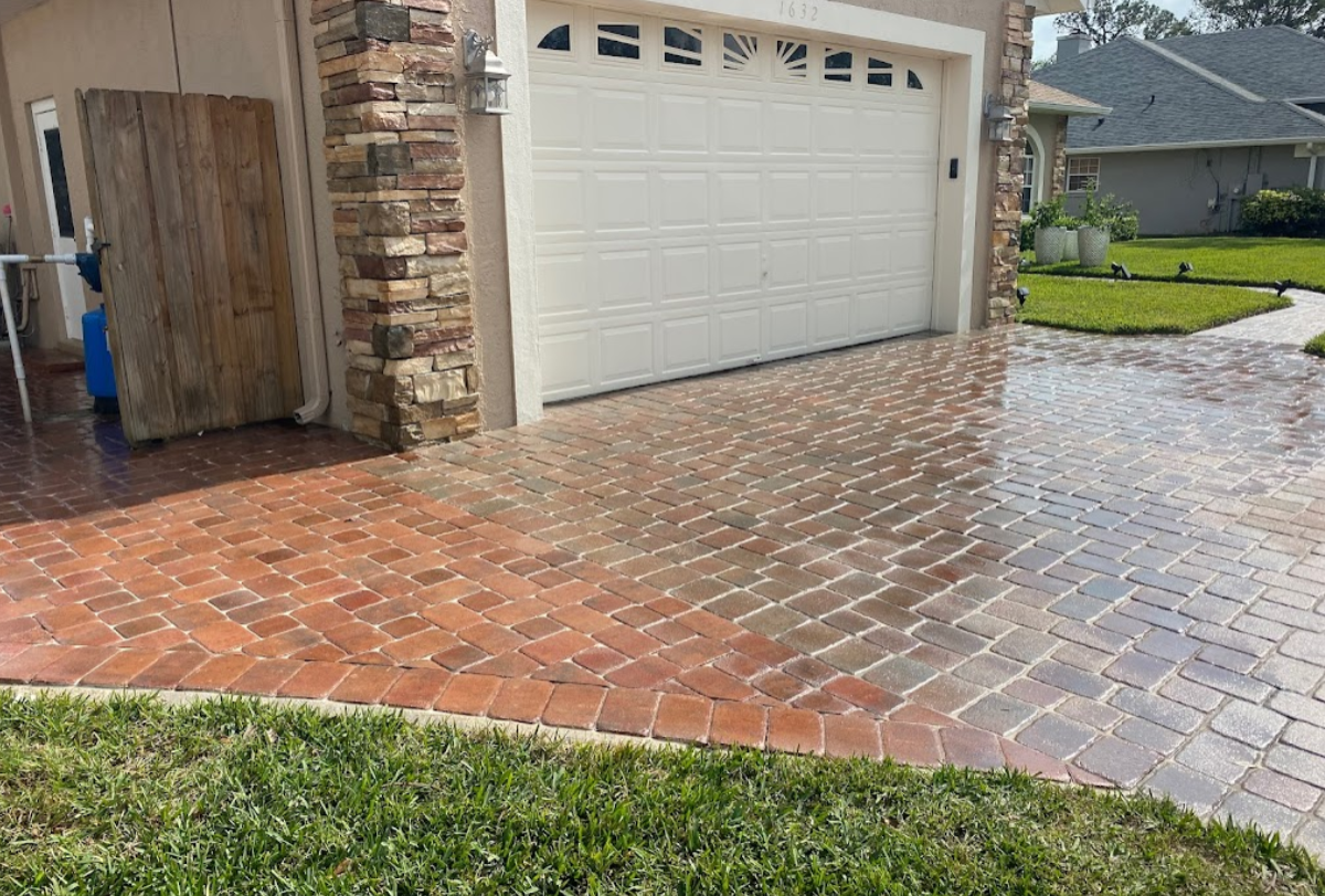 A brick driveway leading to a garage with a white garage door.