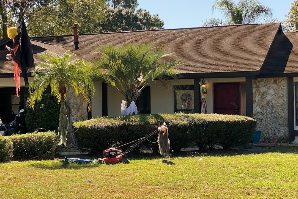 A house with a lawn mower in front of it