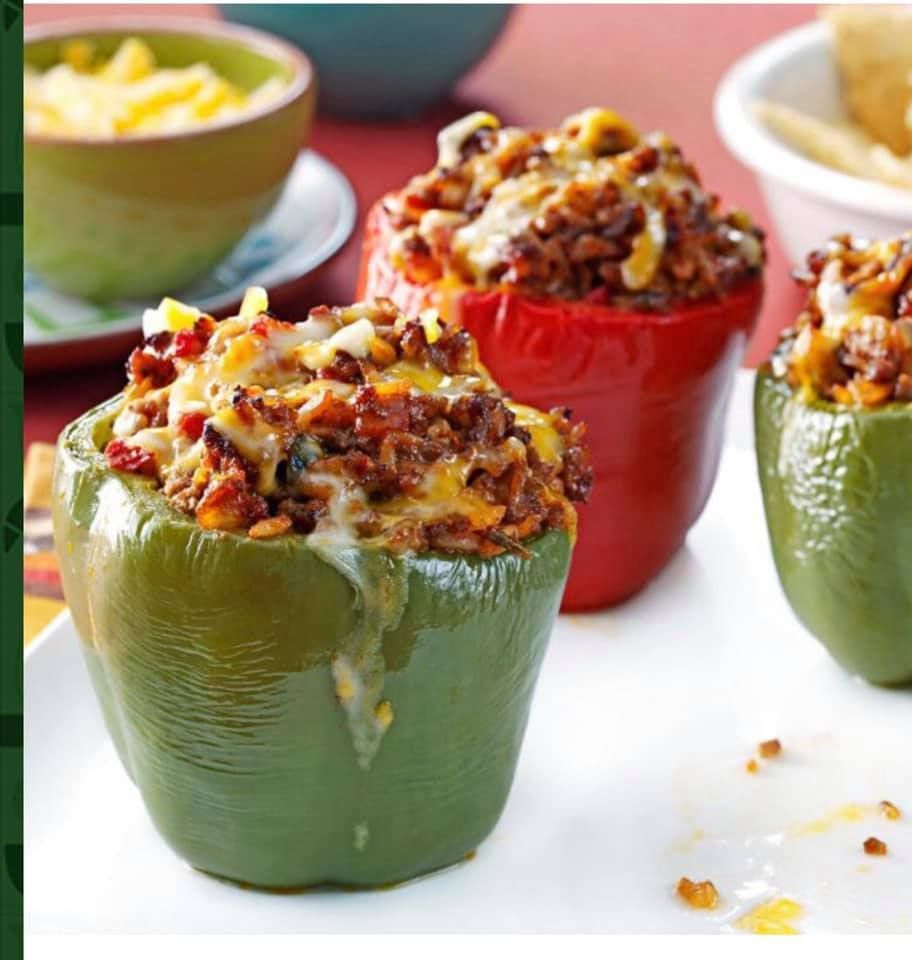 Stuffed bell peppers in red, green, and yellow, filled with ground meat, cheese, and vegetables.