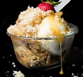 A bowl of dessert with ice cream and a strawberry on top.