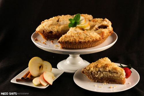 A pie with a slice taken out of it is on a white plate.