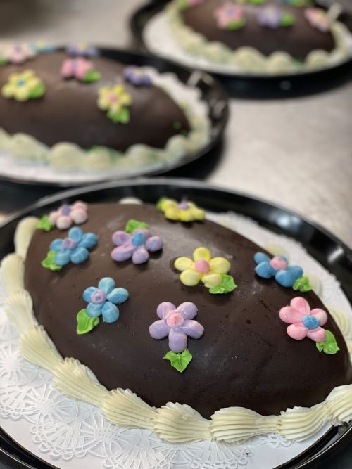 Three dishes of Thanksgiving sides: sweet potatoes with pecans, corn, and carrots.