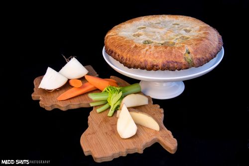 A pie is sitting on a blue plate on a counter.