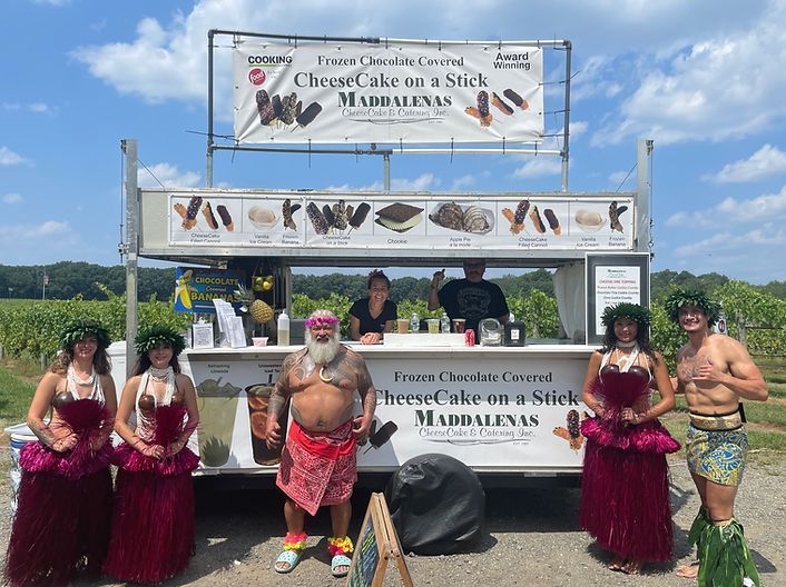 A group of people are standing in front of a food truck.