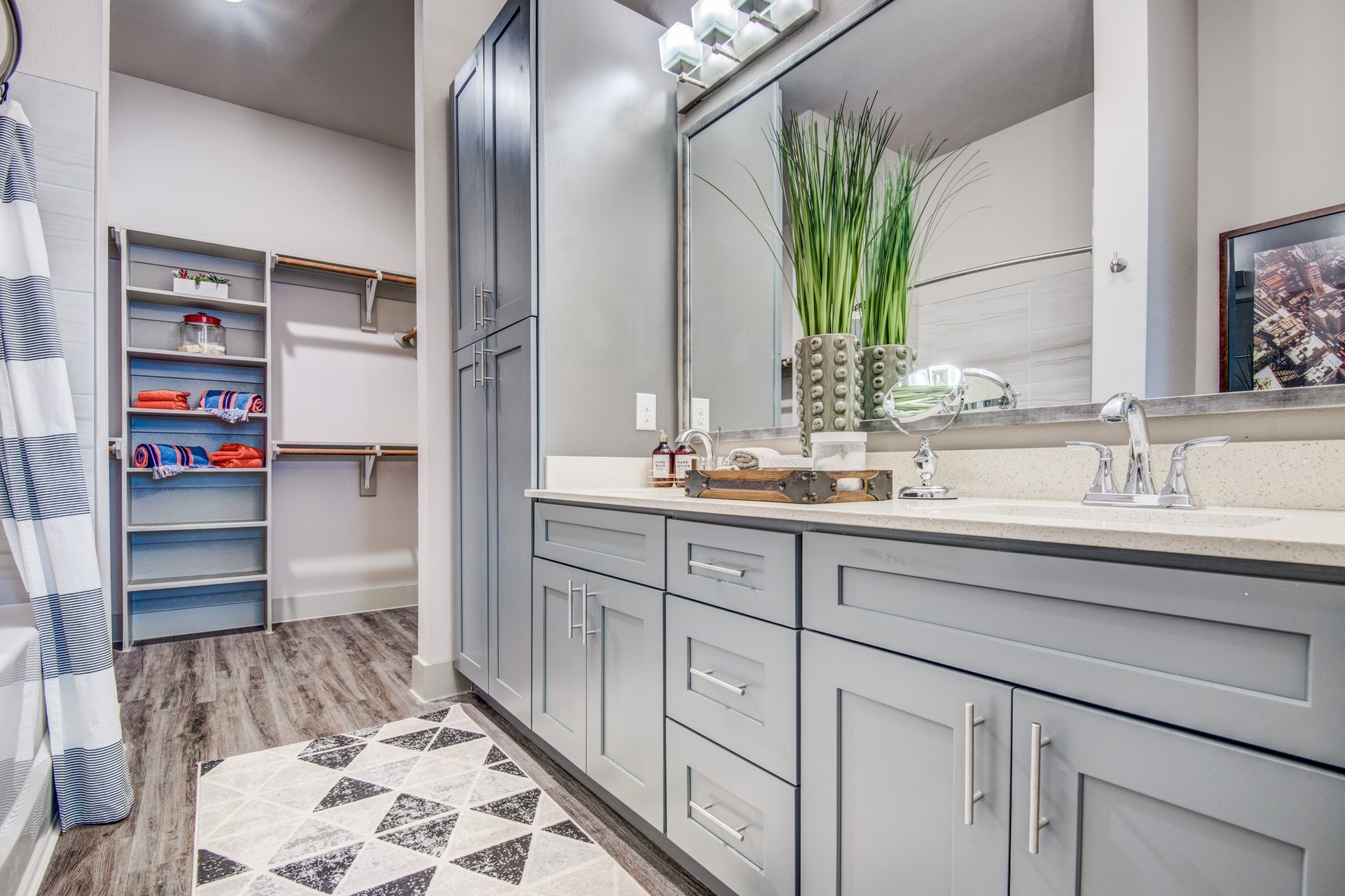A bathroom with two sinks, a large mirror, and a walk-in closet at Two99 Monroe offers apartments for rent in Roanoke, TX.