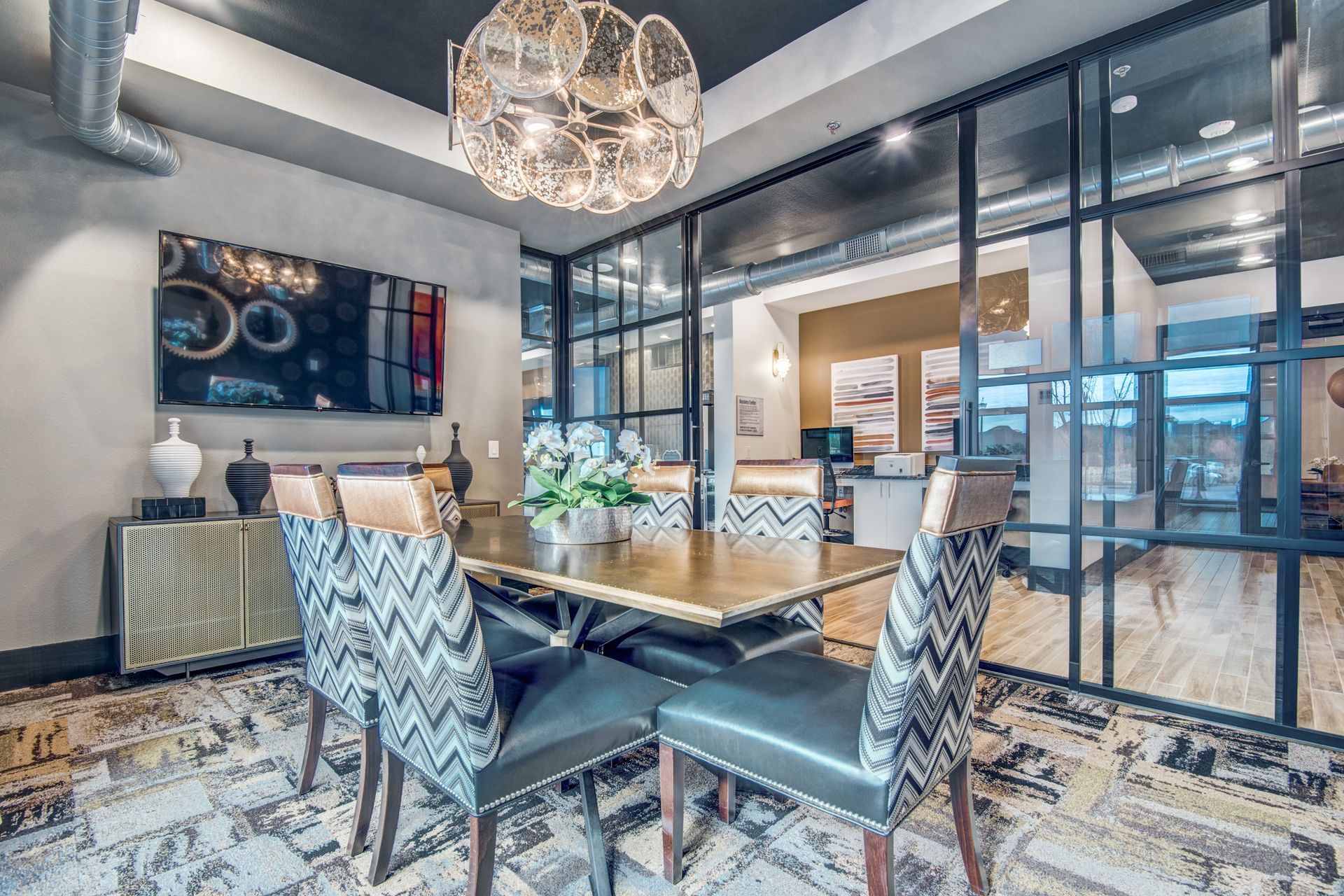 Conference room with a table and chairs and a chandelier at Two99 Monroe offers apartments for rent in Roanoke, TX.