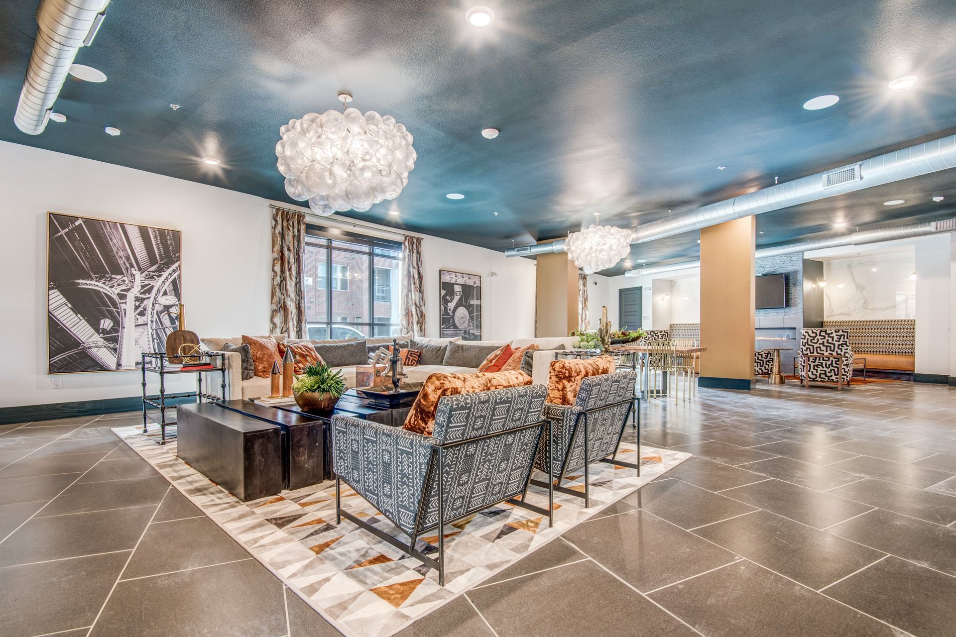 High-ceiling clubhouse filled with furniture and a chandelier at Two99 Monroe offers apartments for rent in Roanoke, TX.