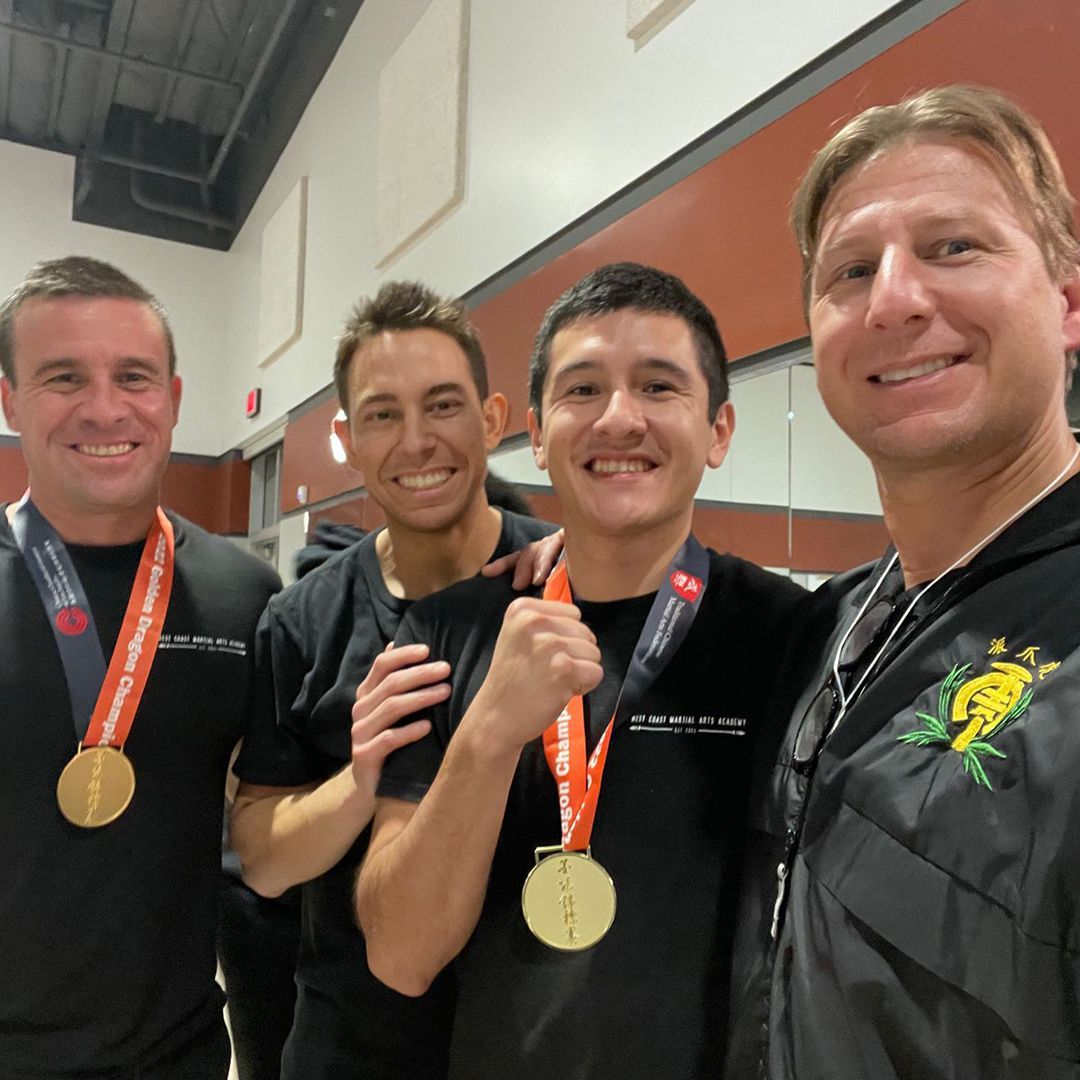 Four men posing for a picture with medals around their necks