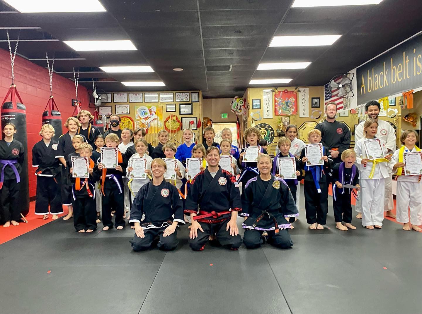 A group of people are posing for a picture in a gym.