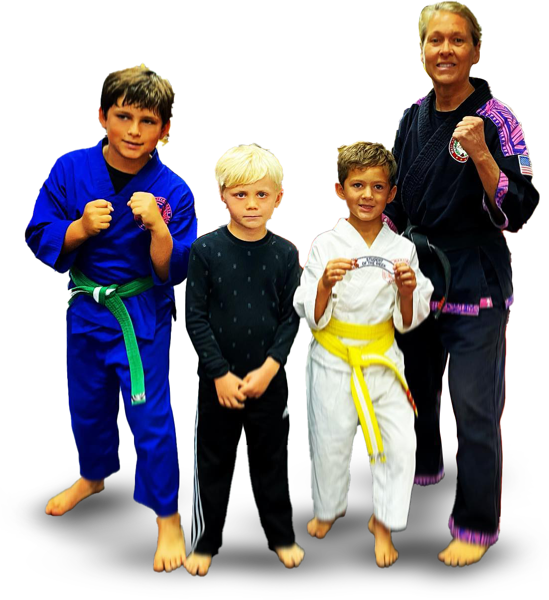 A woman stands next to three young boys in karate uniforms