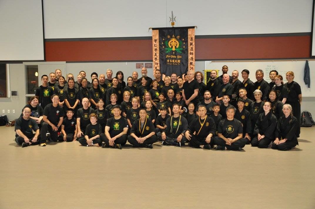 A large group of people are posing for a picture in a room