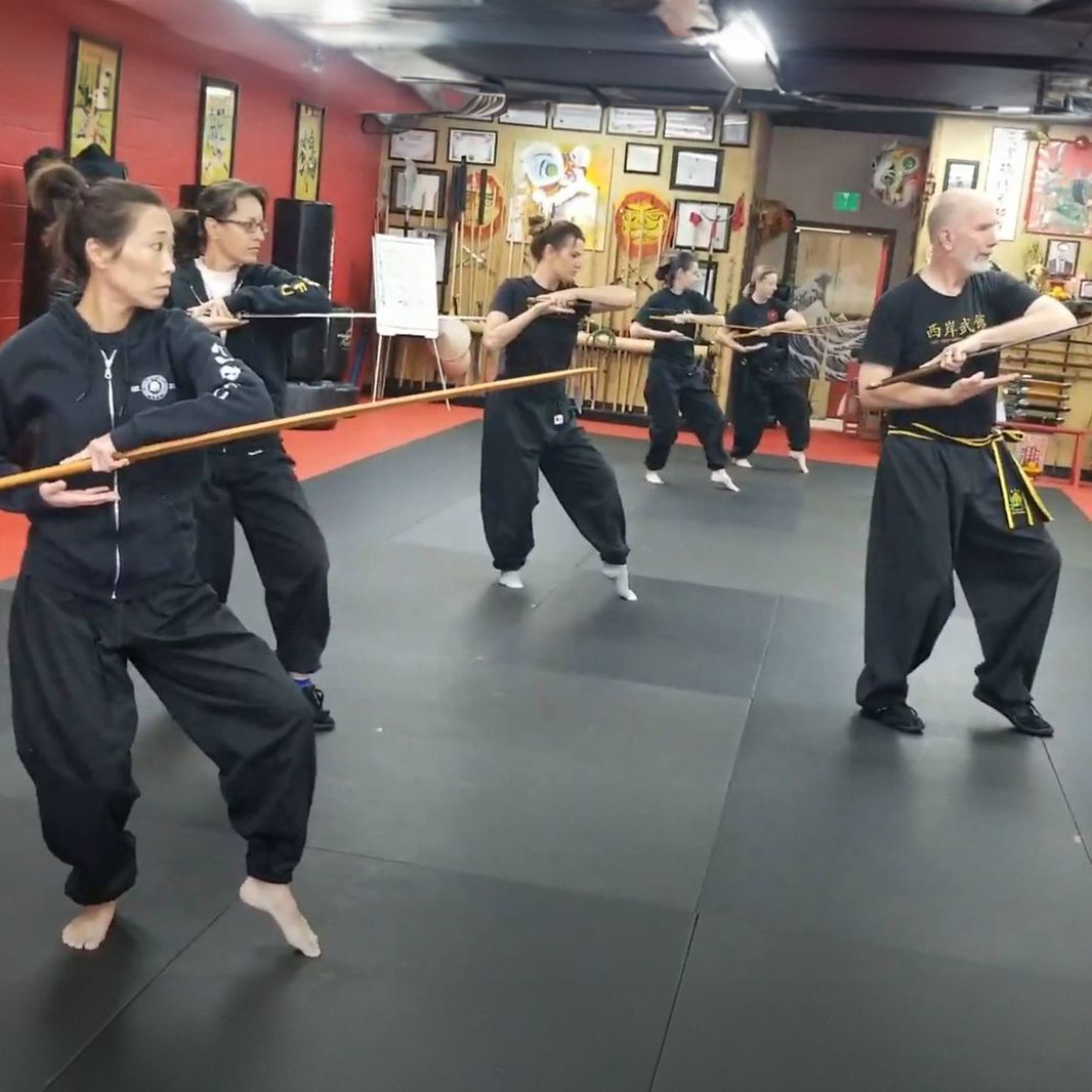 A group of people are practicing martial arts in a gym