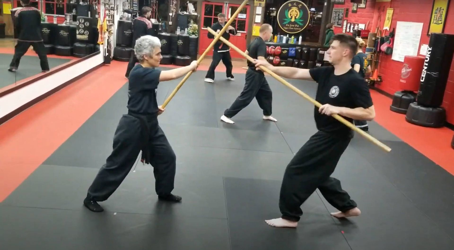 A group of people are practicing martial arts in a gym.