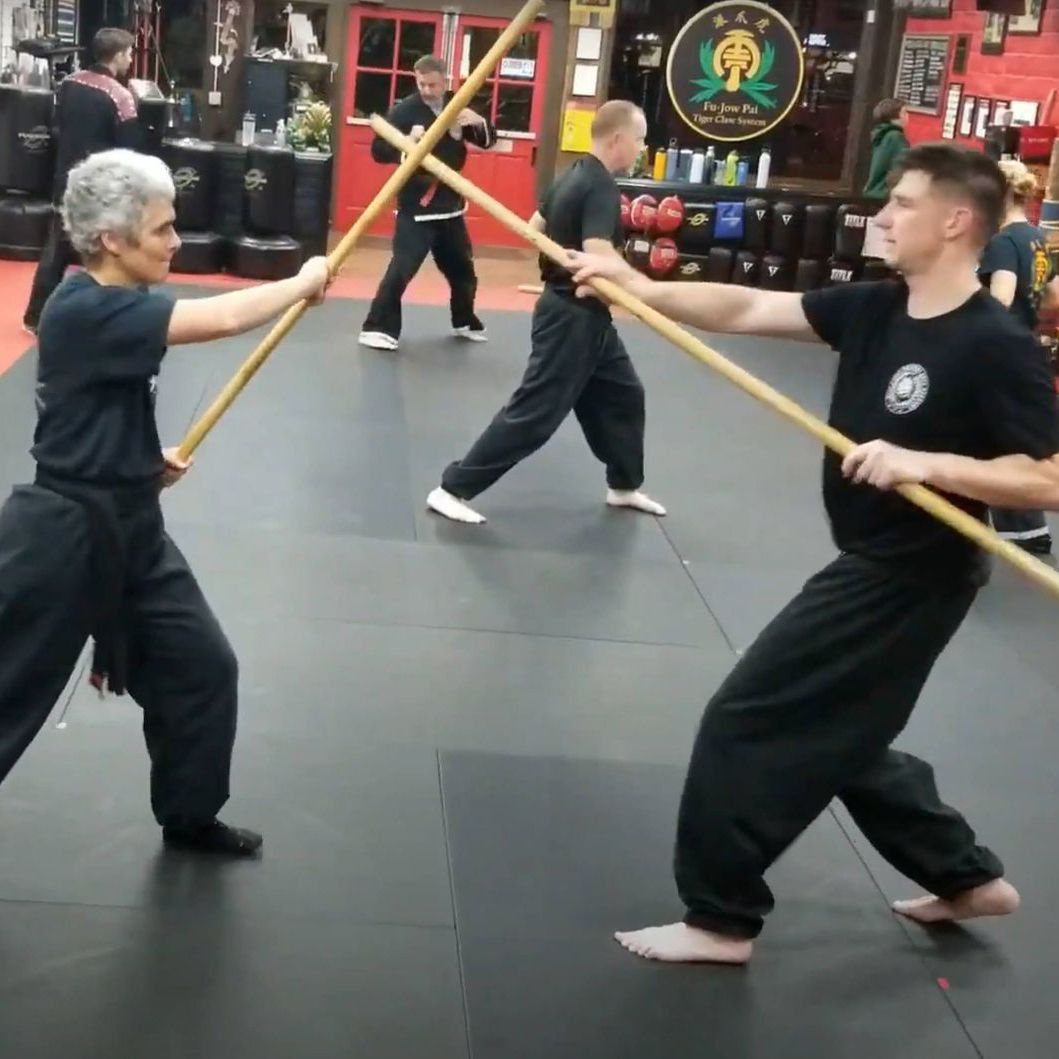 A group of people are practicing martial arts in a gym