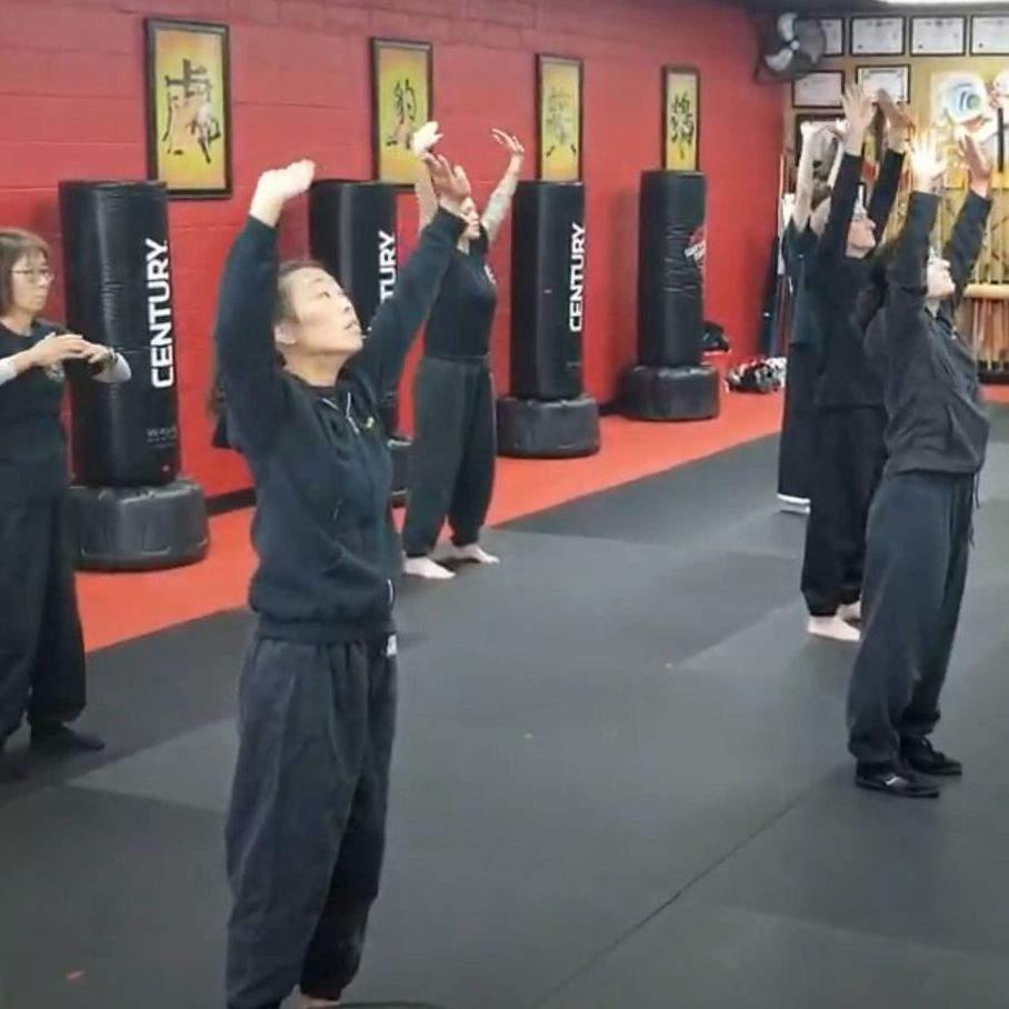 A man and a woman are practicing martial arts on a mat.