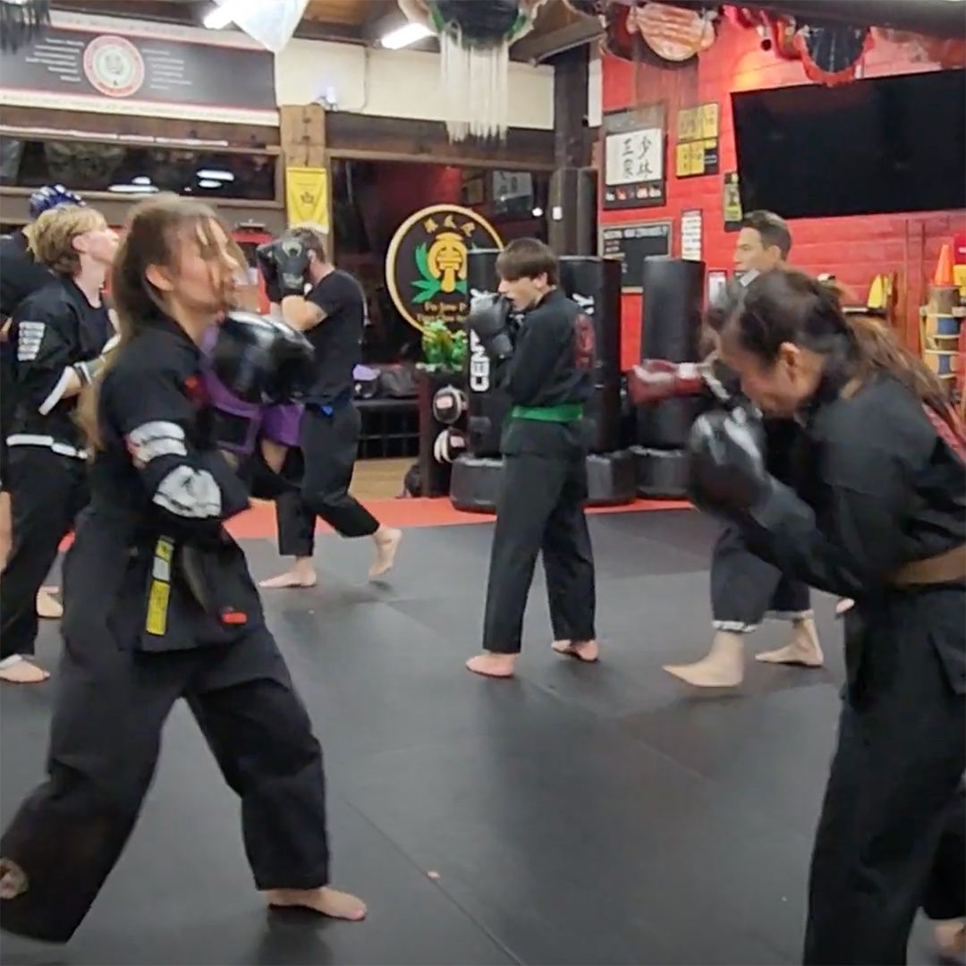 A group of people are practicing martial arts in a gym