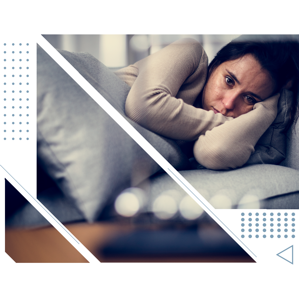 A woman is laying on a couch with her head resting on a pillow.