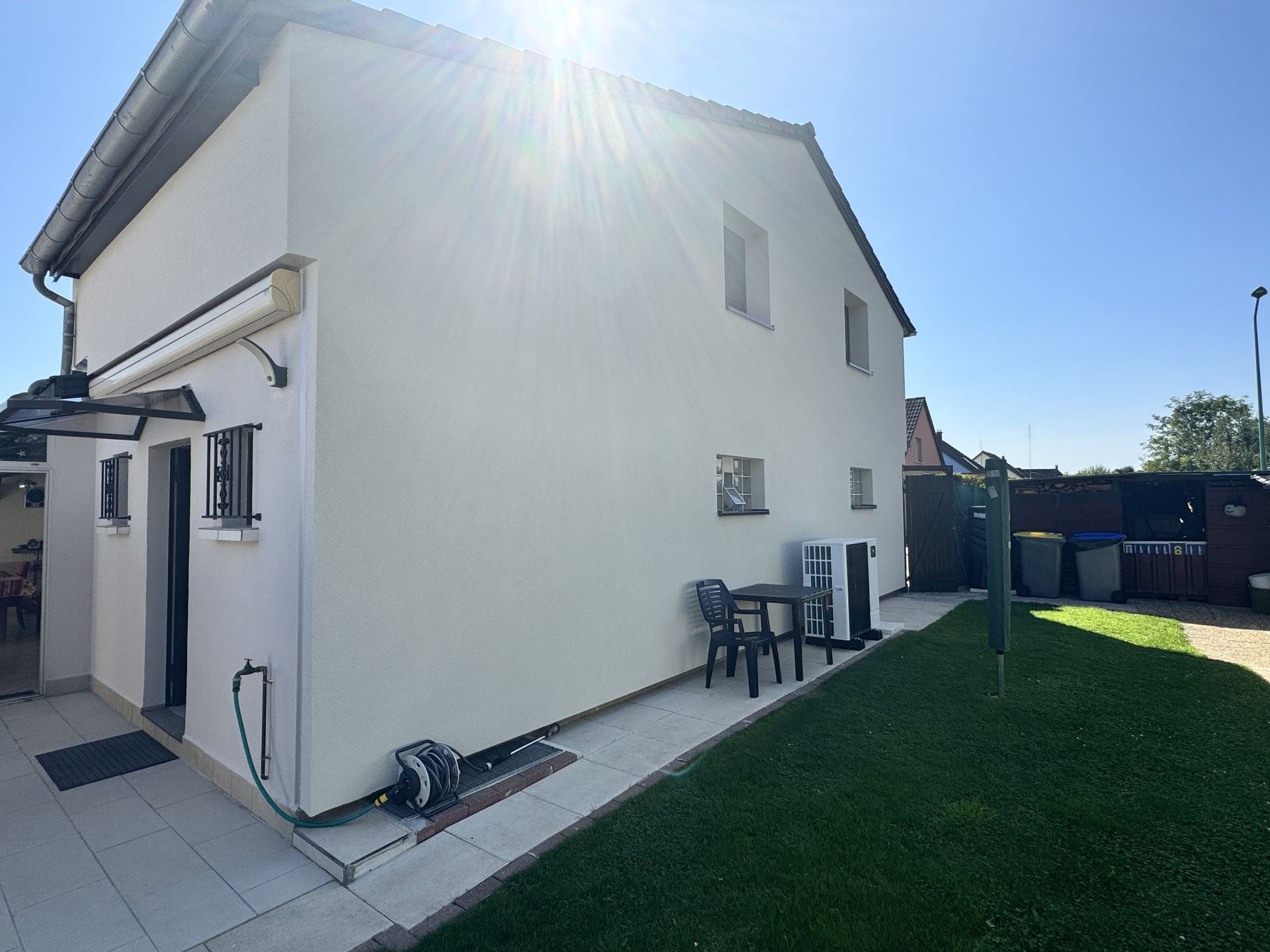 Une maison blanche avec une table et des chaises devant
