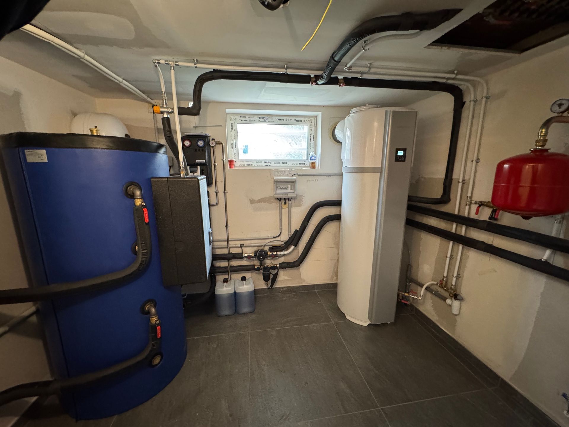 Une pièce avec un réservoir bleu et un réfrigérateur blanc