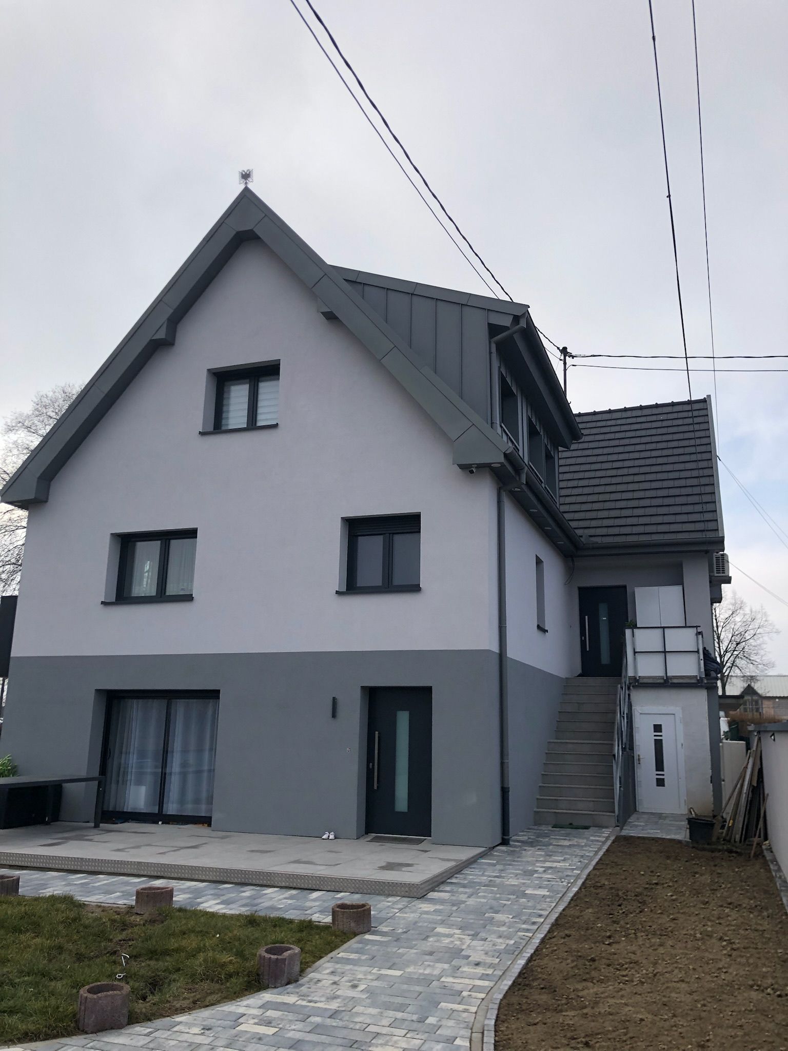 Une grande maison blanche avec un toit gris
