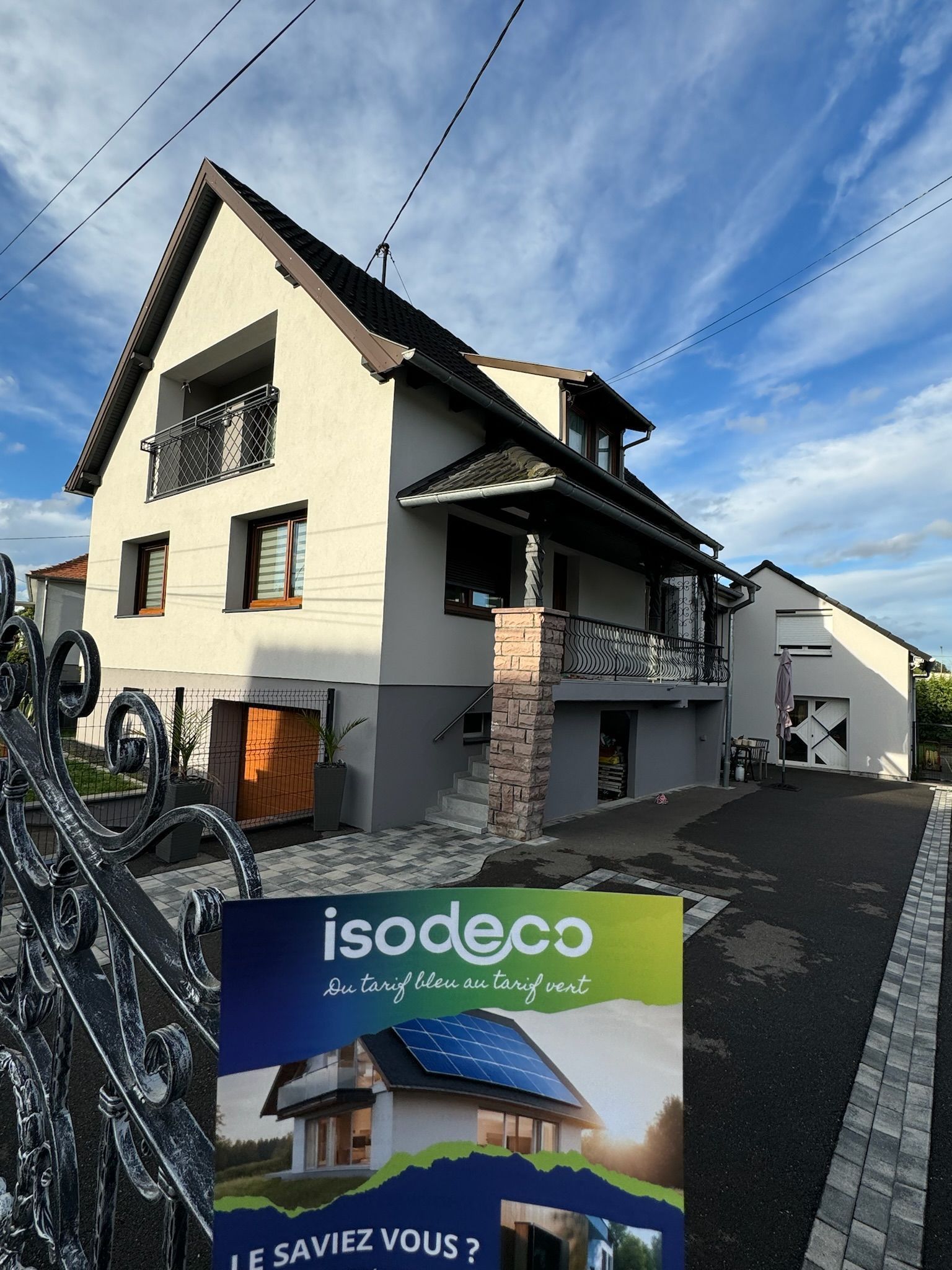 Une maison avec un panneau indiquant isodeco devant