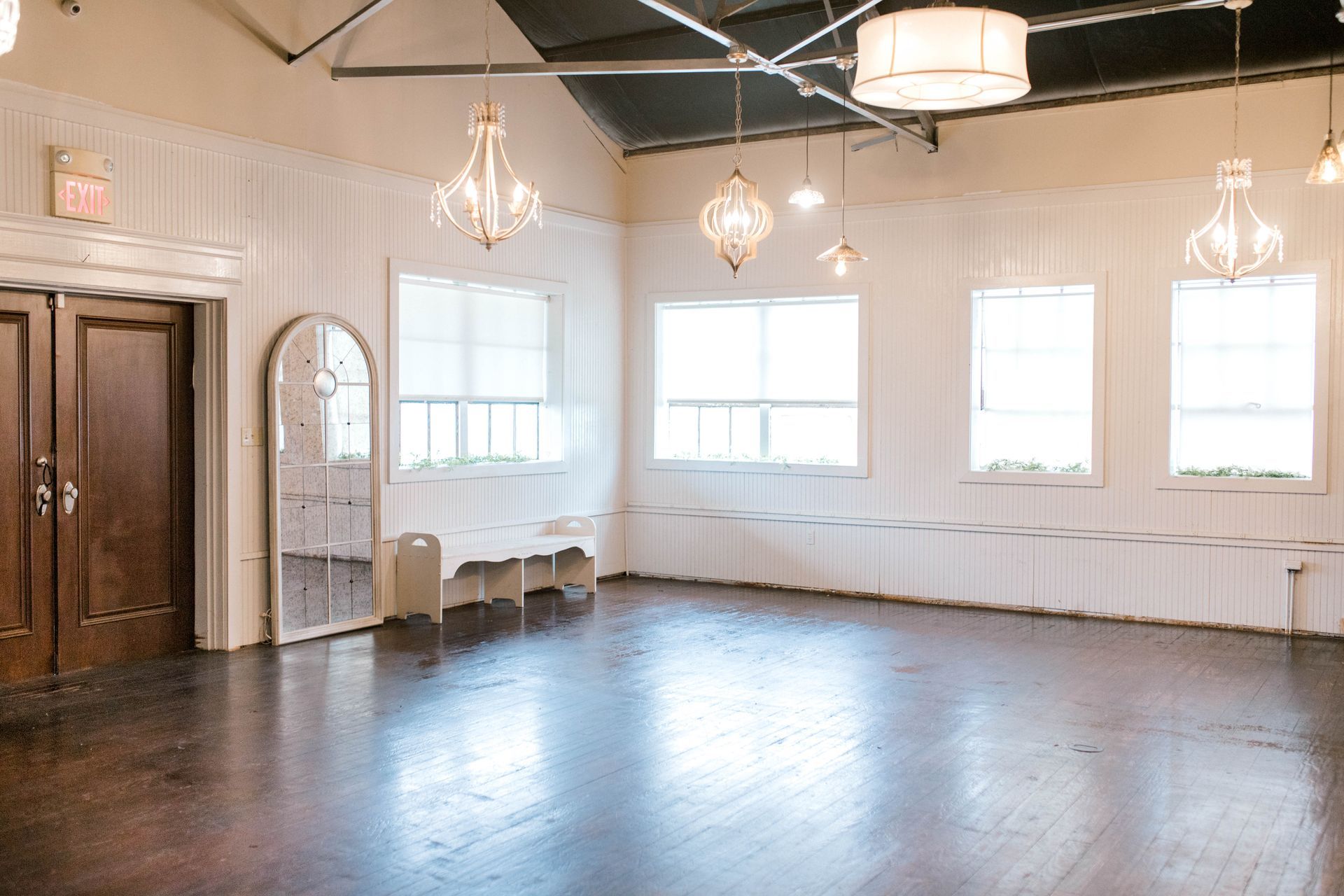 A large empty room with wooden floors and white walls.