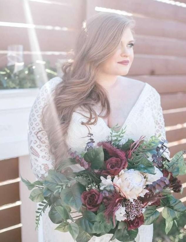A woman in a white dress is holding a bouquet of flowers.