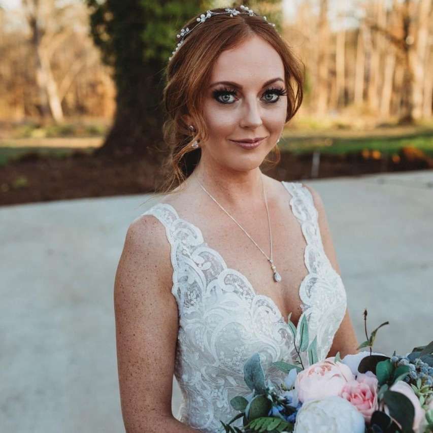 A woman in a wedding dress is holding a bouquet of flowers.