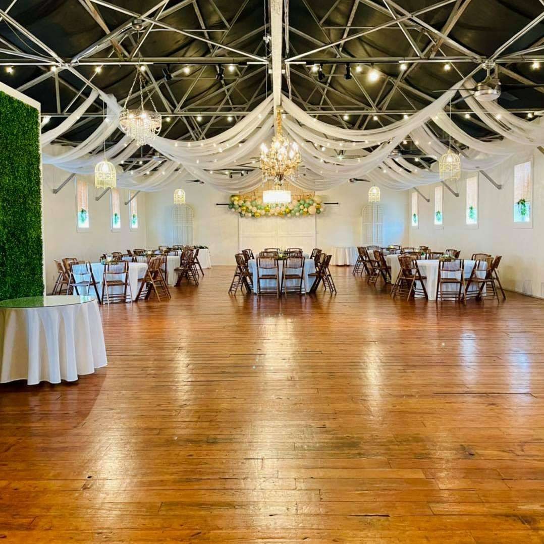A large room with tables and chairs set up for a wedding reception.
