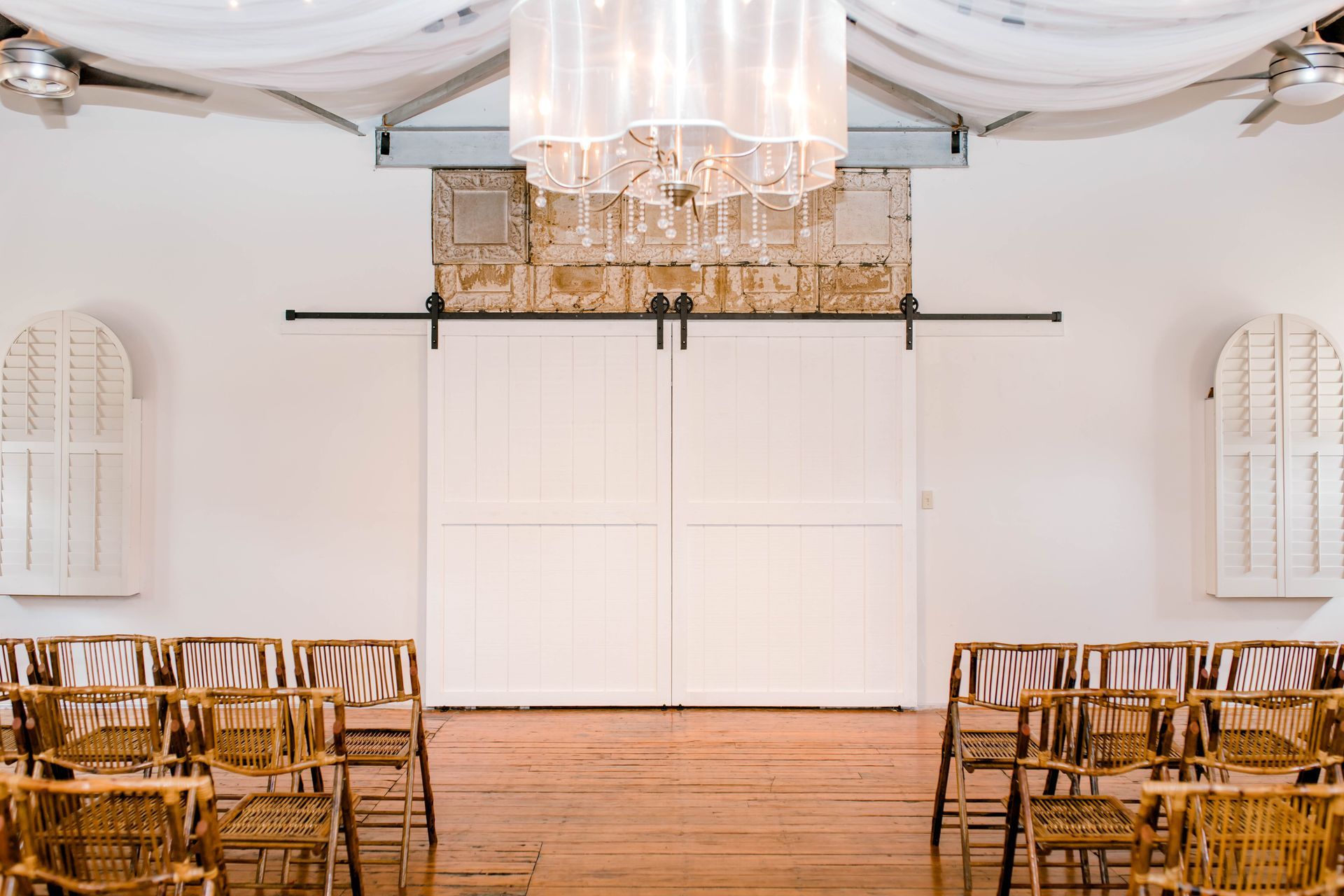 There are rows of chairs in a room with a sliding barn door.