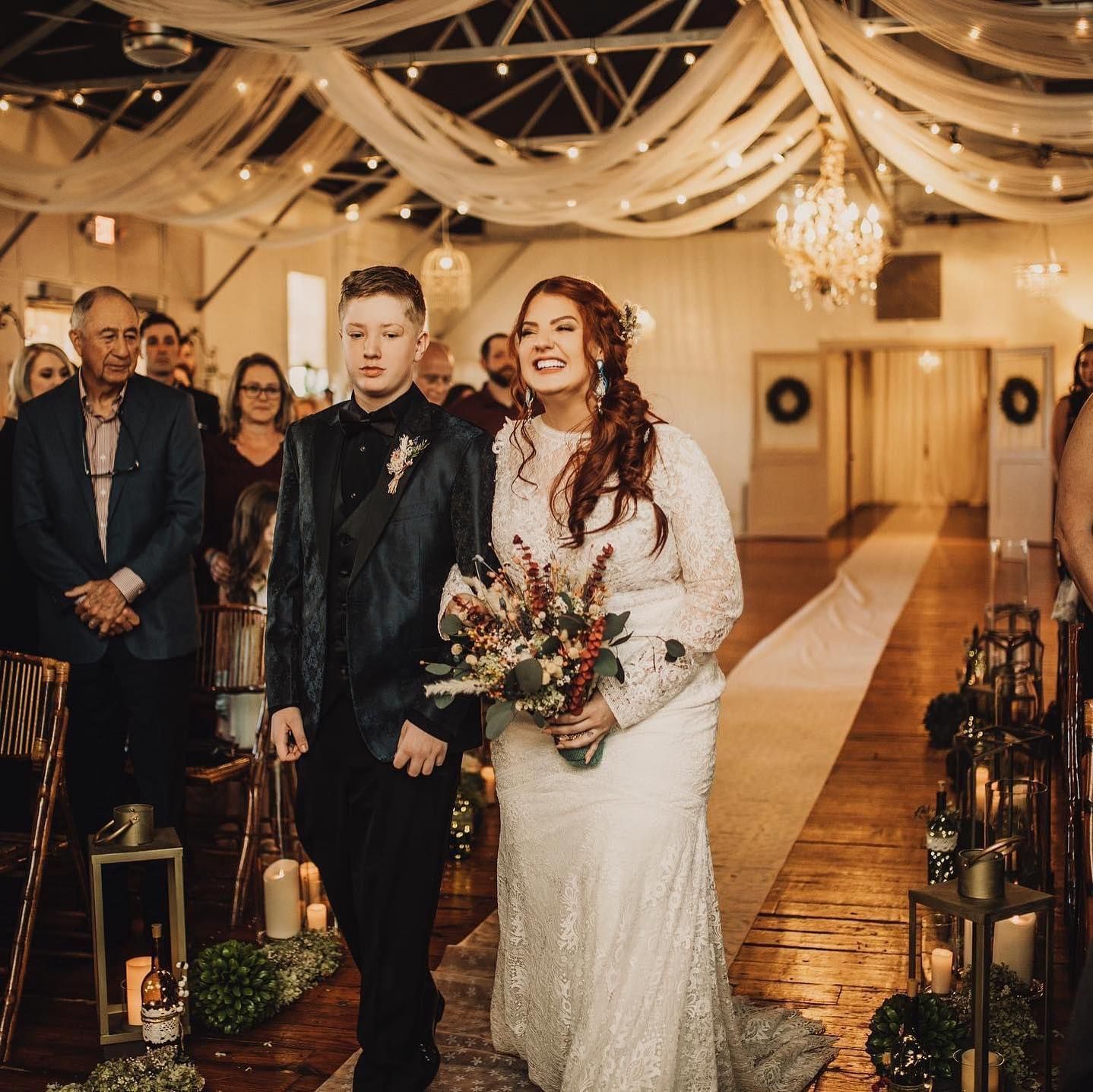 A bride and groom are walking down the aisle at their wedding