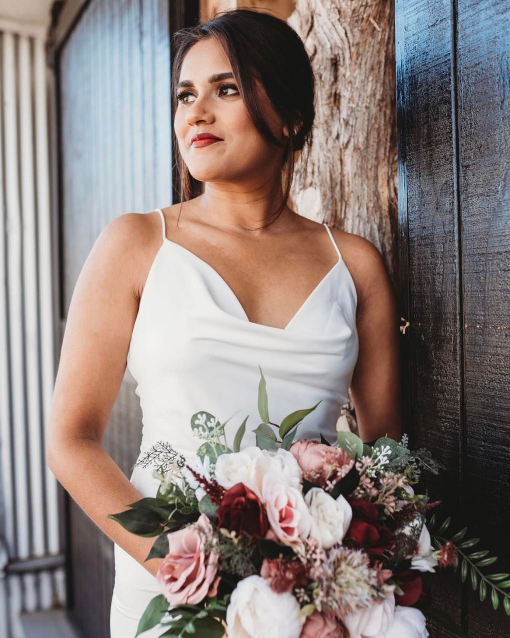 A woman in a white dress is holding a bouquet of flowers.