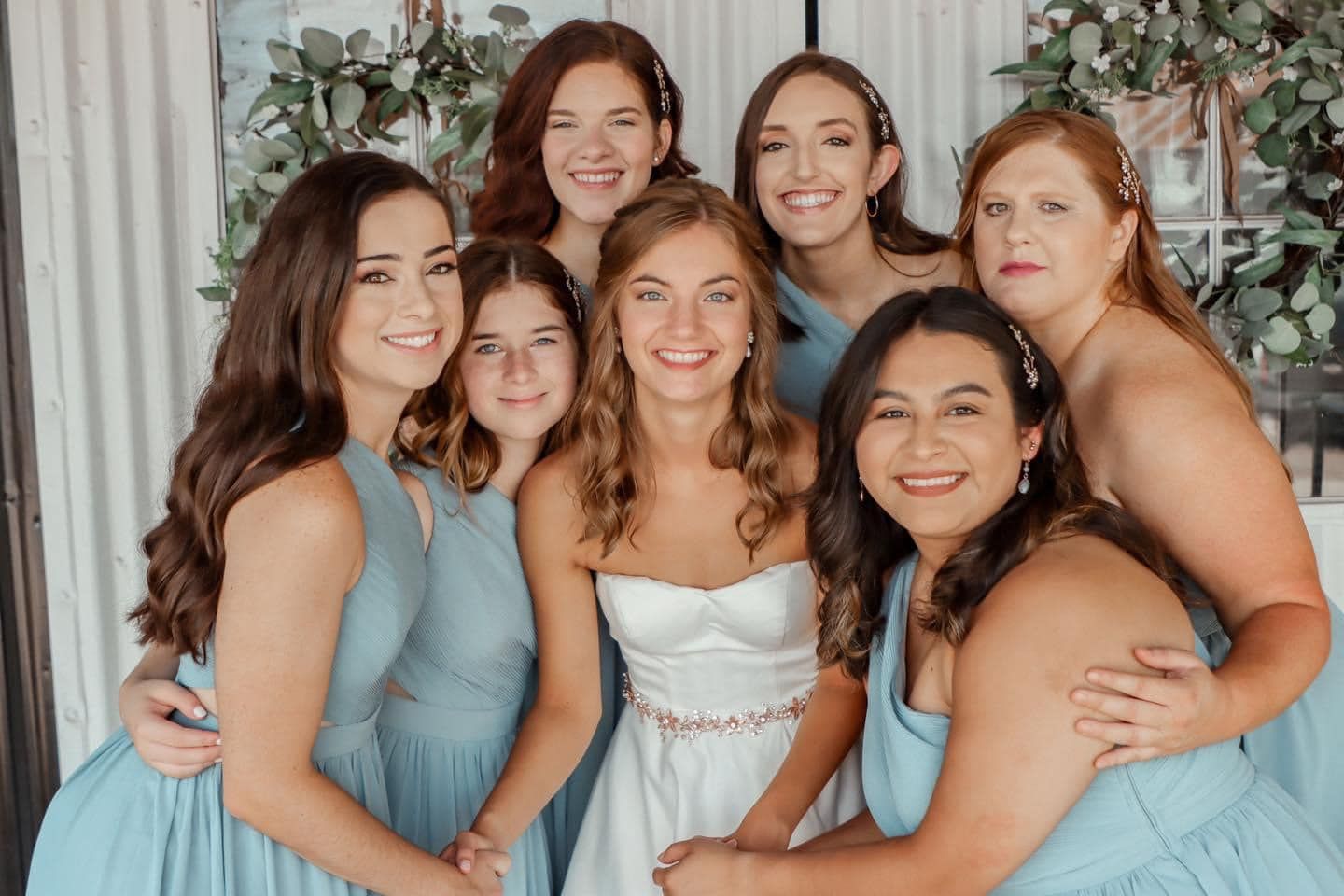 A bride and her bridesmaids are posing for a picture together.