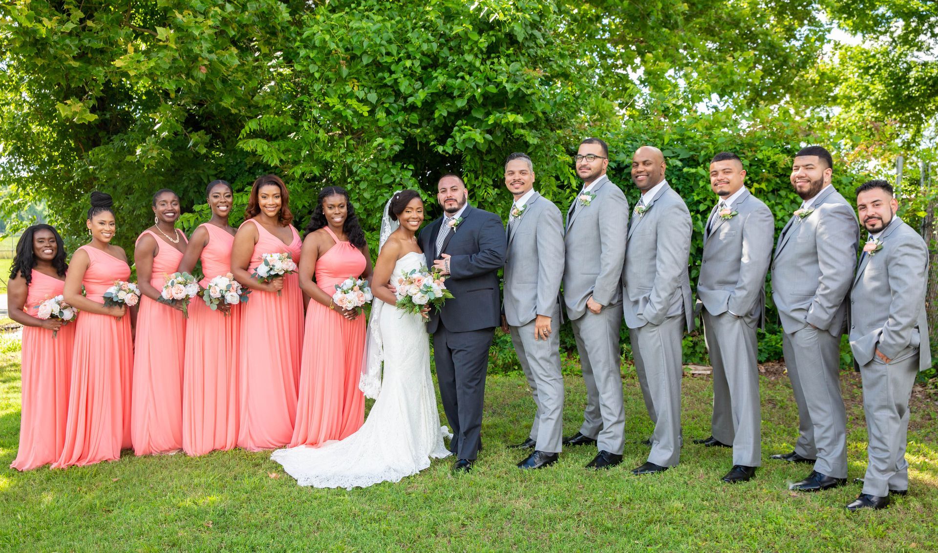 The bride and groom are posing for a picture with their wedding party.