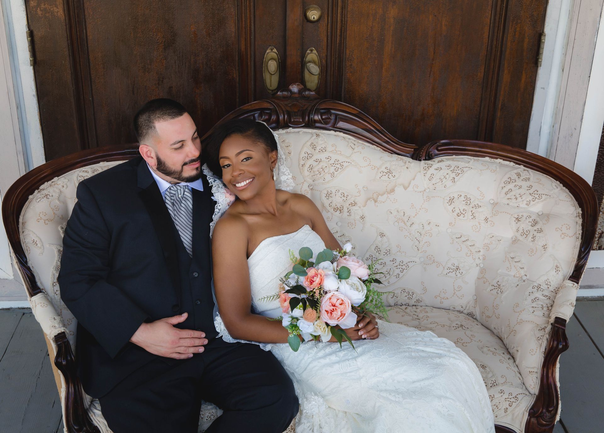 A bride and groom are sitting on a couch.