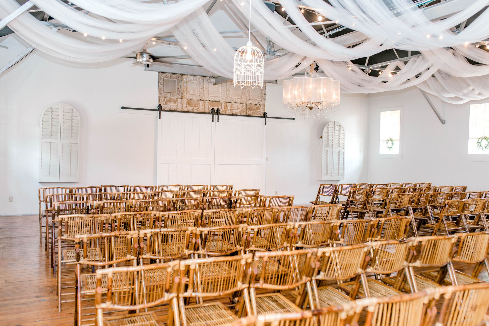 Rows of wooden chairs are lined up in a large room.