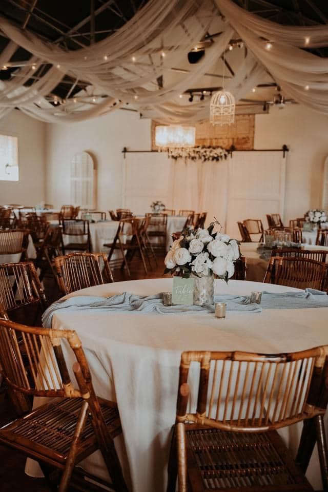 A large room with tables and chairs set up for a wedding reception.