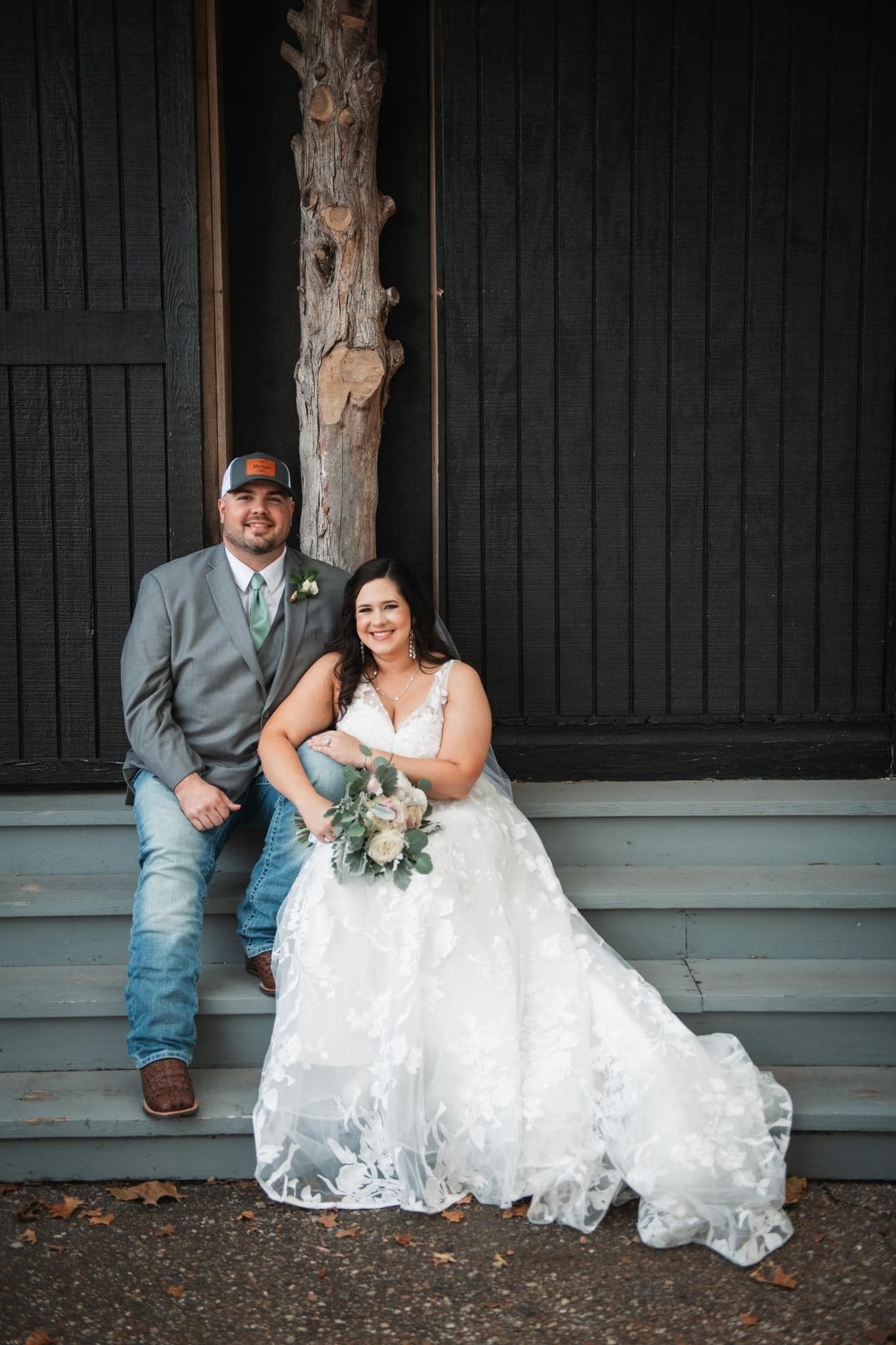 A bride and groom are posing for a picture on the steps of a building.