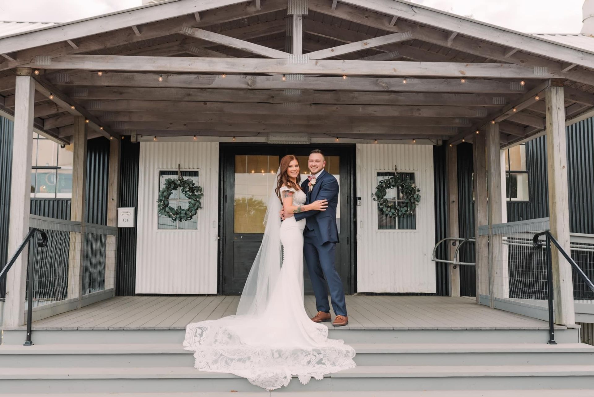 A bride and groom are posing for a picture in front of a building.