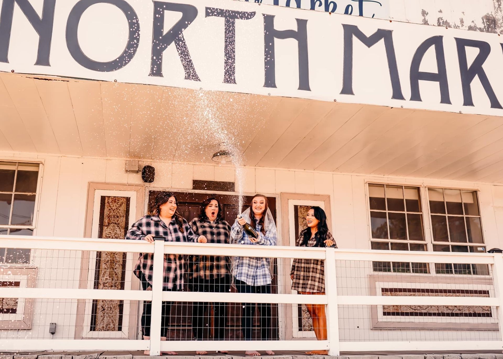 A group of people standing on a balcony under a sign that says north mar