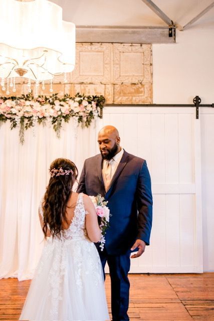 A bride and groom are standing next to each other in a room.