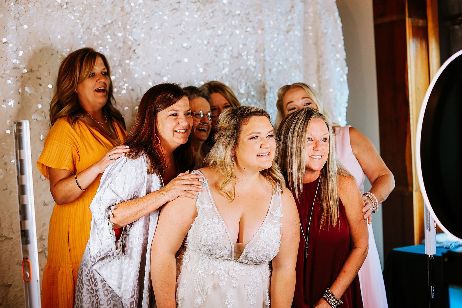 A group of women are posing for a picture in front of a photo booth.