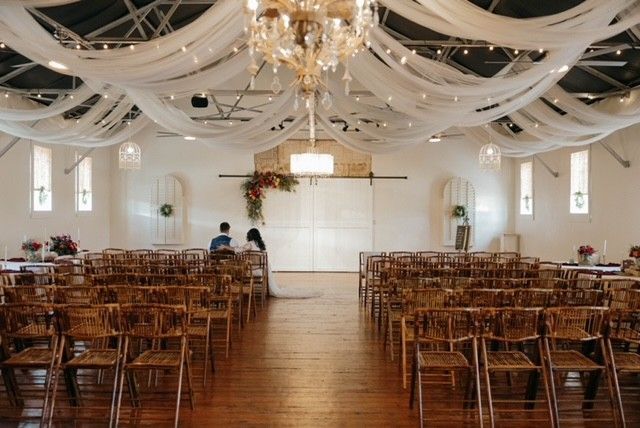 A large room filled with wooden chairs and a chandelier.