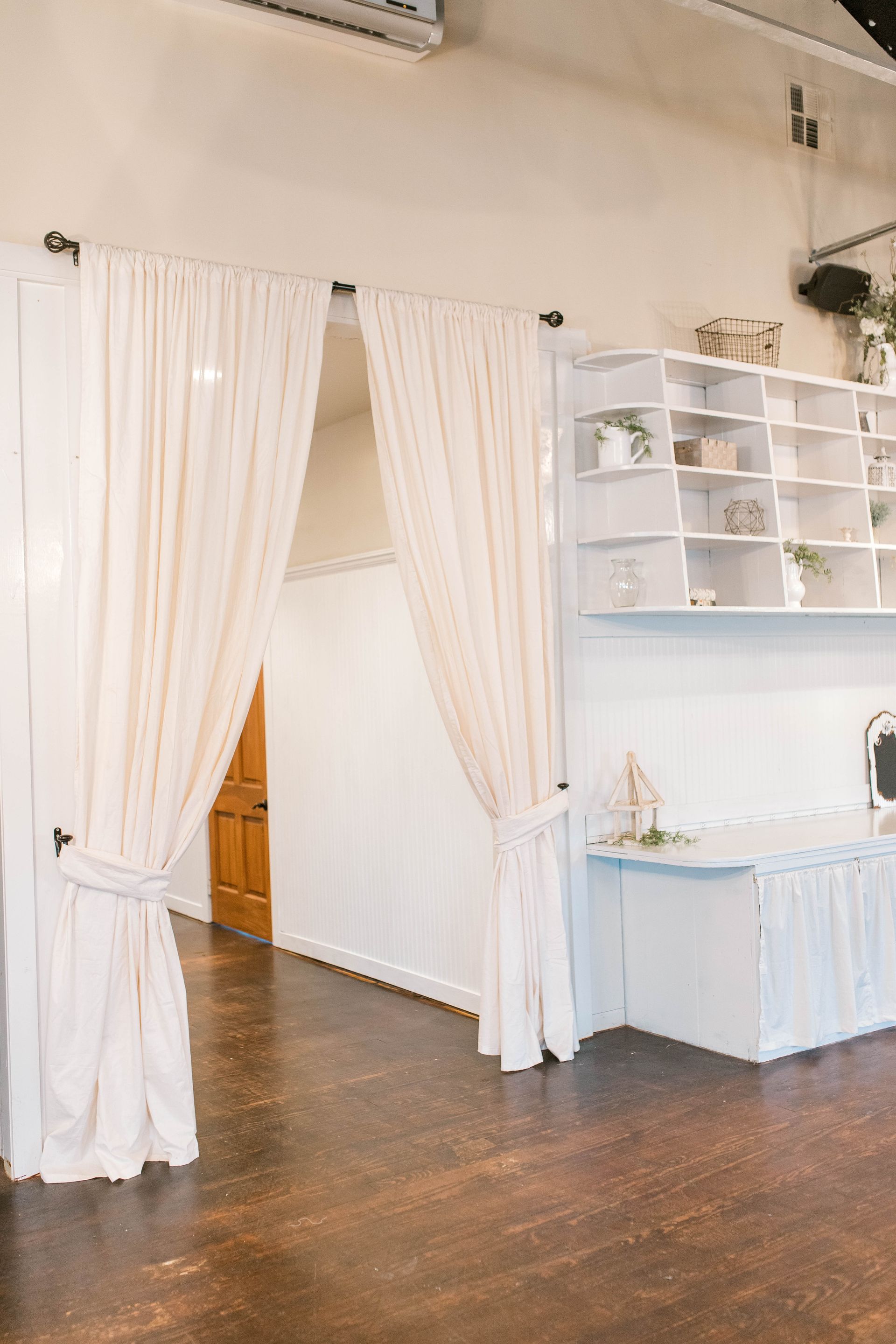 A room with white curtains and a wooden floor.