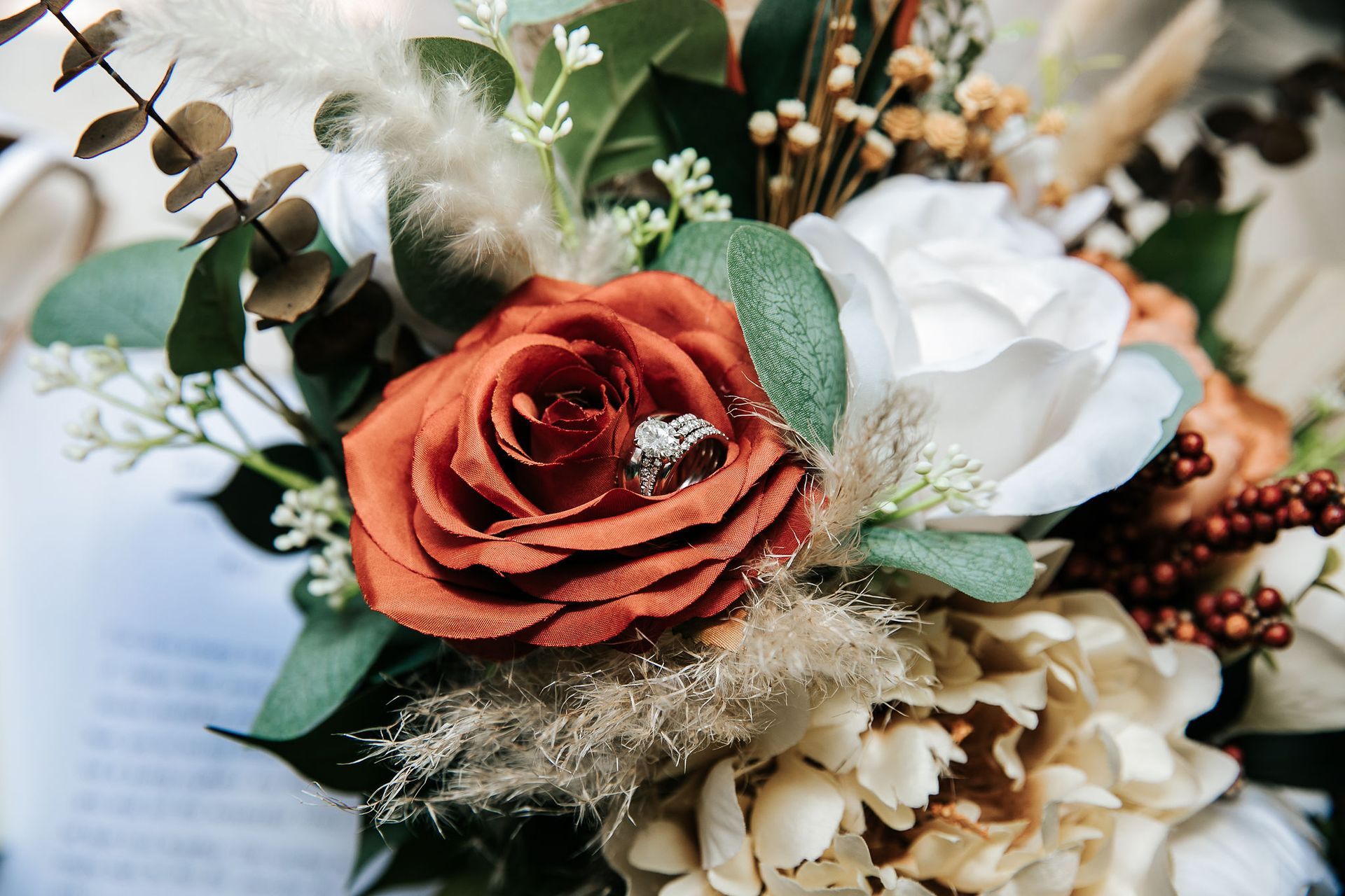A wedding ring is sitting on top of a bouquet of flowers.